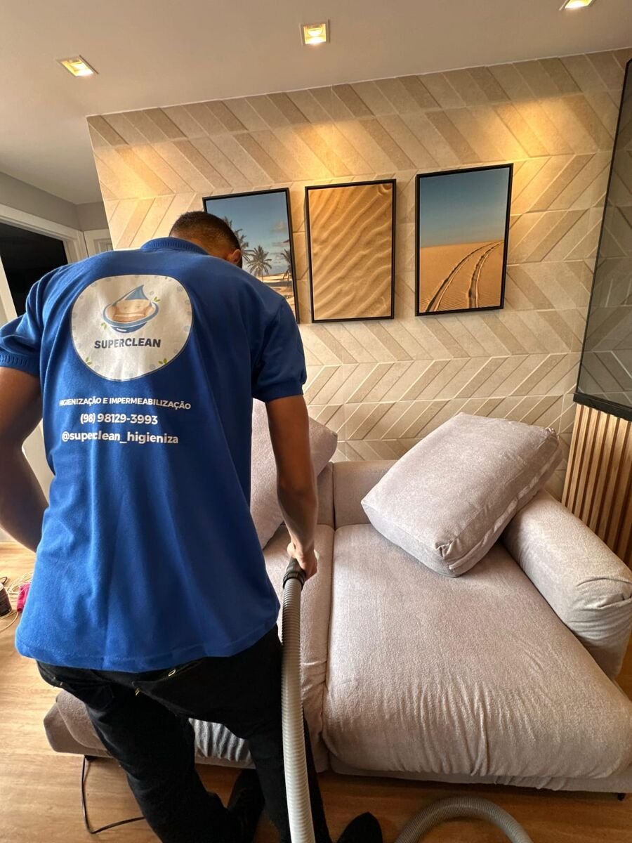 Profissional da SuperClean higienizando um sofá em residência